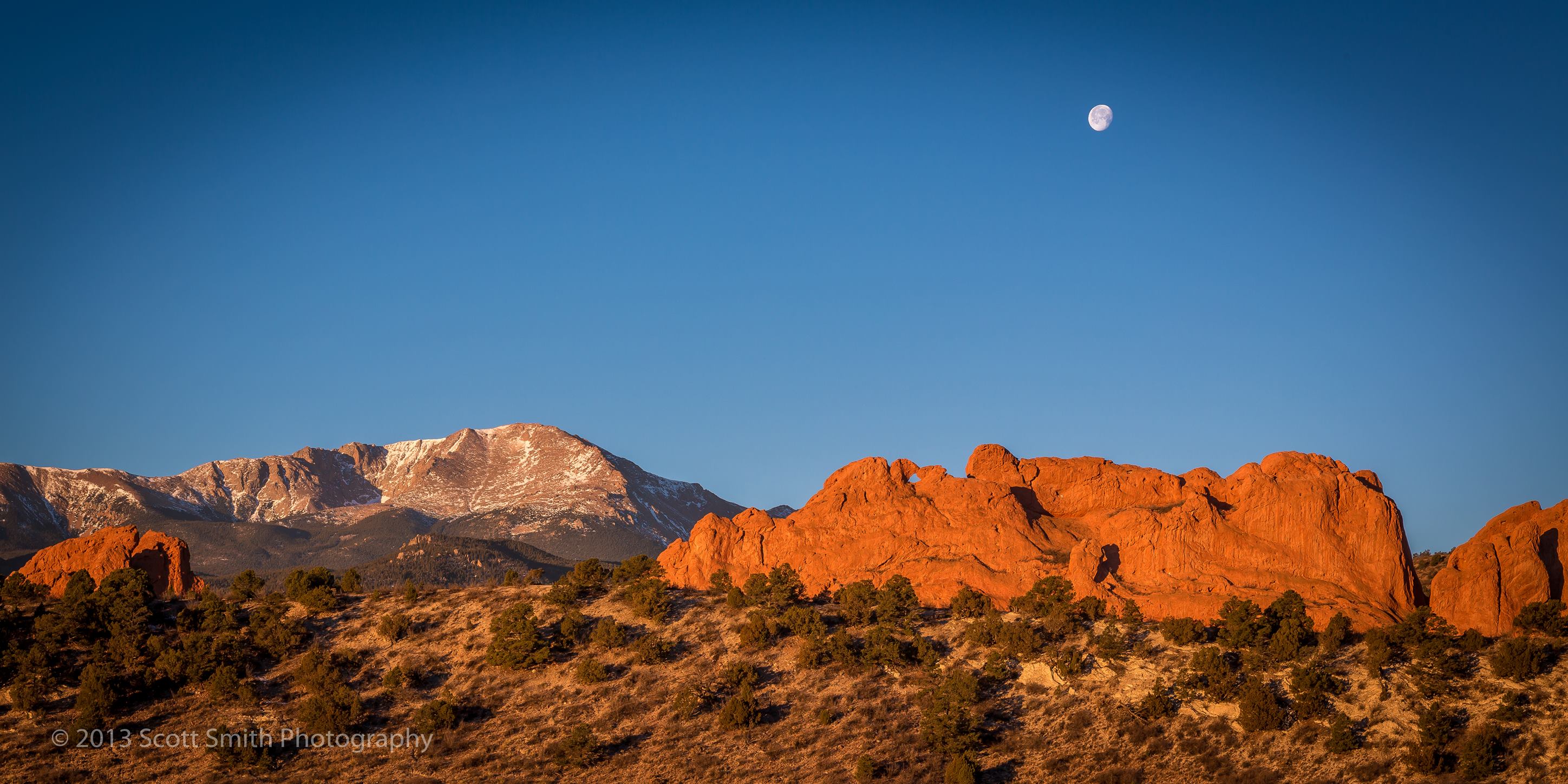 Sun Rising, Moon Setting - The moon sets as the morning sun lights up the Garden of the Gods and Pike's Peak in Manitou Springs, Colorado. by Scott Smith Photos